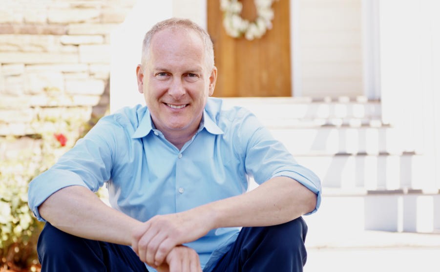Elderly man sitting in front his house at dawn